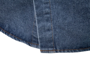Macro view of dark blue cotton denim fabric with orange contrast stitching details