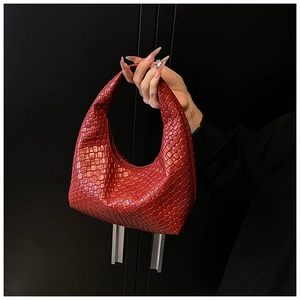 Close-up of the intricate red woven texture and seamless handle on this hobo bag