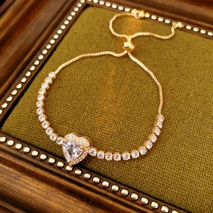 Detail of adjustable heart bracelet with sparkling zircon stones in a golden finish