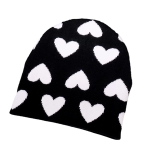 Berretto in maglia alla moda con cuori bianchi su tessuto nero per calore invernale
