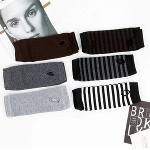 Detail of various striped and solid knitted arm warmers with thumb holes on white background