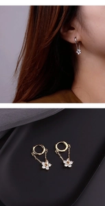 Detailed close-up of zircon flower drop earrings in gold and silver finishes