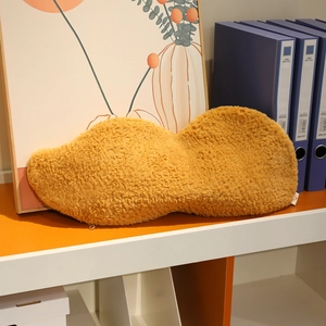 Detail shot of the hidden zipper on a yellow peanut-shaped plush pillow with lamb wool texture