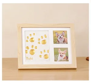 Detailed view of DIY pet paw print keepsake frame with gold clay and photo slots
