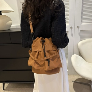 Sac seau marron à cordon en tissu oxford porté à l'épaule vu de dos sur un mannequin