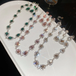 Macro shot of sparkling teardrop gemstone necklaces in green, pink, and white crystal colors