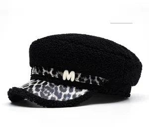 Close-up of black faux shearling texture with leopard print brim and metallic M detail