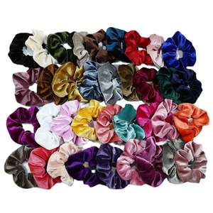 Lot de chouchous en velours colorés aux teintes variées comme le bordeaux sur fond blanc