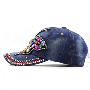 Detail of blue denim baseball hat with colorful rhinestones and crystal butterfly gems