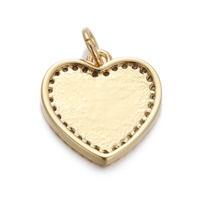 Detail view of a textured heart pendant in gold finish with decorative dot edges