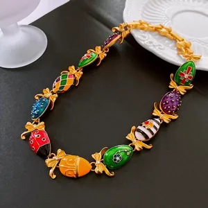 Vintage gold bow necklace with colorful enamel egg charms and retro floral patterns