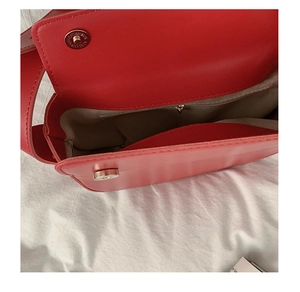 Detail view of red PU leather saddle bag showing the inner compartment and magnetic closure