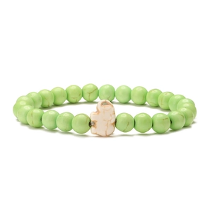 Detailed view of light green beaded elephant bracelet with white marbled bead charm