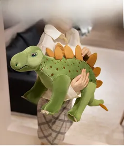 Close-up of soft green plush stegosaurus toy with brown plates held by a child