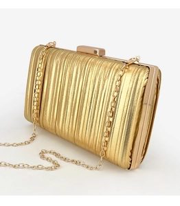Close-up of golden evening clutch featuring pleated texture and elegant metal frame with chain