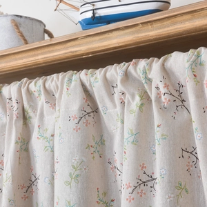 Detail of floral linen cafe curtain showing olive leaf print and textured fabric