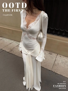 Détail de l'encolure en V avec dentelle et manches évasées sur la robe longue en satin