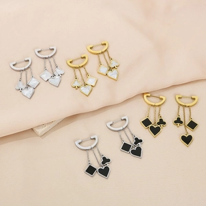 Detail of tassel earrings featuring poker heart and club charms with shell and enamel inlay