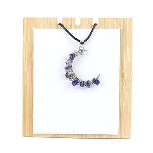 Detailed close-up of blue crystal stone chips hand-wrapped in silver wire moon pendant