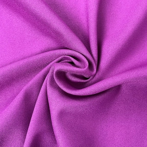 Detailed macro view of bright purple crepe fabric with subtle grainy texture and rich sheen