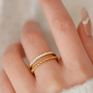 Close-up of a double-layered gold ring with sparkling pavé stones and twisted rope detail
