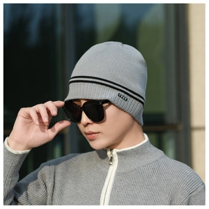 Detail of grey winter knit beanie with black stripes and FBQE label on model