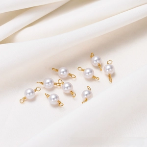 Detail of 9 handmade 18K gold-plated wire-wrapped white pearl connectors for DIY jewelry