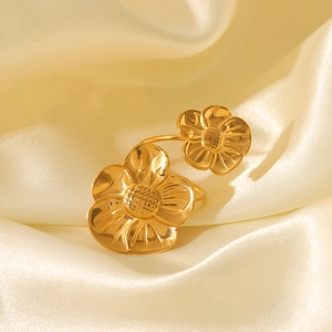 Macro shot of gold vintage flower ring with brushed metal texture on satin background