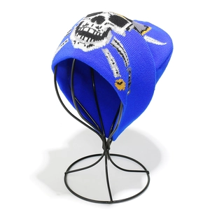 Detailed view of blue knitted beanie with white skull and crossbones jacquard pattern