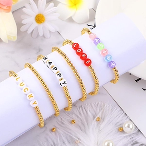 Set of four gold beaded bracelets with FAMILY, LOVE, HAPPY, and LUCKY letter charms