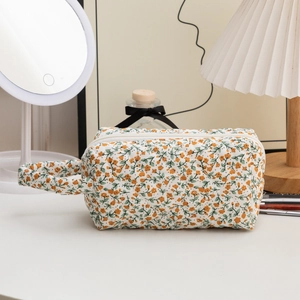 Quilted floral cosmetic bag detail featuring orange flower print and soft cotton fabric