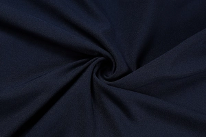 Close-up of deep blue knit fabric showing refined texture and elegant drape detail
