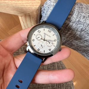 Close-up of DOUKOU quartz watch with silver metal case and blue silicone strap detail