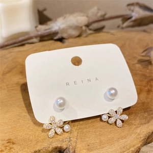 Detail of flower pearl ear jackets with gold alloy petals and sparkling white zircons