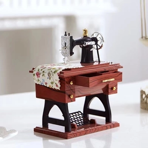 Vintage sewing machine music box in mahogany finish with realistic fabric and metal details