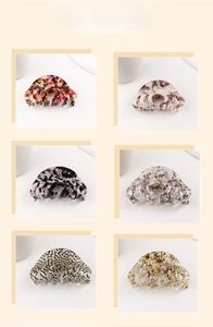 Macro display of six vintage acetate hair claws featuring diverse marble and floral patterns