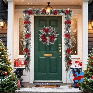 Christmas wreath and garland set with red poinsettia and snowy pine needles on a door