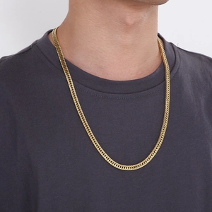 Hip hop style gold curb chain necklace made of stainless steel worn by a male model