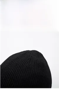 Close-up of men's black winter knit hat featuring thick vertical striped ribbed texture