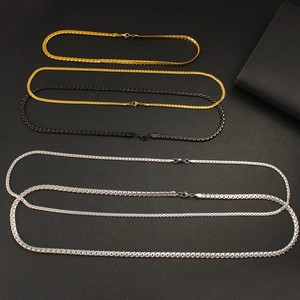 Cuban link necklaces in gold, black, and silver finishes on a textured background