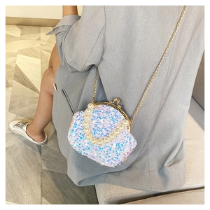 Close-up of sparkling sequin bag with elegant pearl handle and gold chain strap details