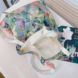 Detail of floral canvas tote bag featuring interior pocket and artistic flower patterns
