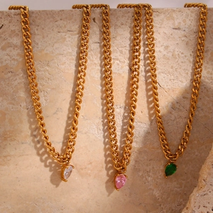Close-up of heart-shaped zircon pendants in pink, green, and clear on gold cuban chains