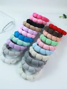 Detailed view of colorful plush bubble hair ties in velvet on a white background