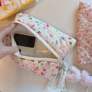 Détail de la pochette matelassée en coton rose à fleurs avec zip blanc et perles