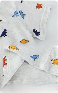 Detail of sleeve cuff and hem stitching on boys' grey cartoon dinosaur cotton T-shirt