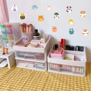 Multi-layer white plastic desk organizer with cute animal stickers on a yellow tablecloth