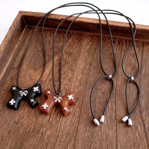 Detail of vintage wooden bow pendants with zircon star accents on black cords