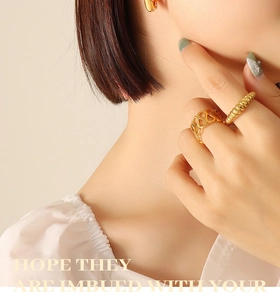 Detail of 18K gold plated hollow honeycomb and twisted rope rings on model hands