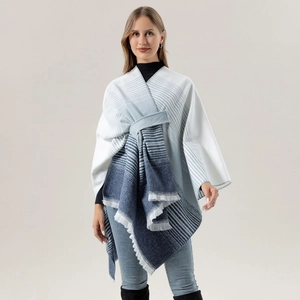 Detail of blue and white gradient knitted shawl with striped pattern and fringe edges